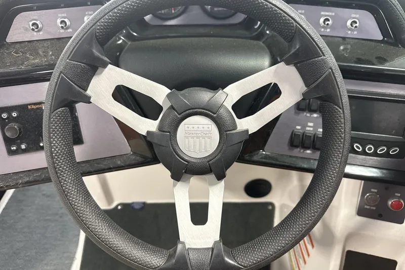 Slide: The Image of Steering wheel of a 2021 MasterCraft NXT24 boat with dashboard controls. - 14