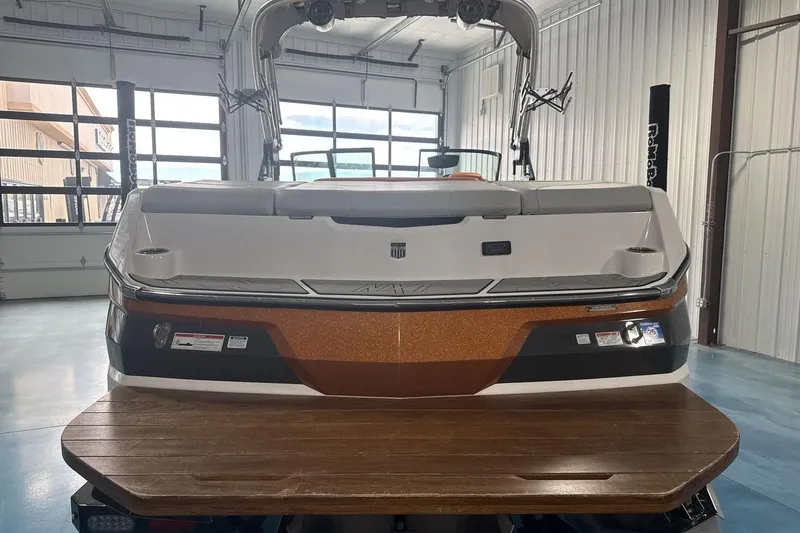 Slide: The Image of 2021 MasterCraft NXT24 boat in a garage, rear view with swim platform. - 4