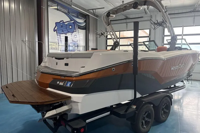 Slide: The Image of 2021 MasterCraft NXT24 boat in showroom, featuring sleek design and modern features. - 5