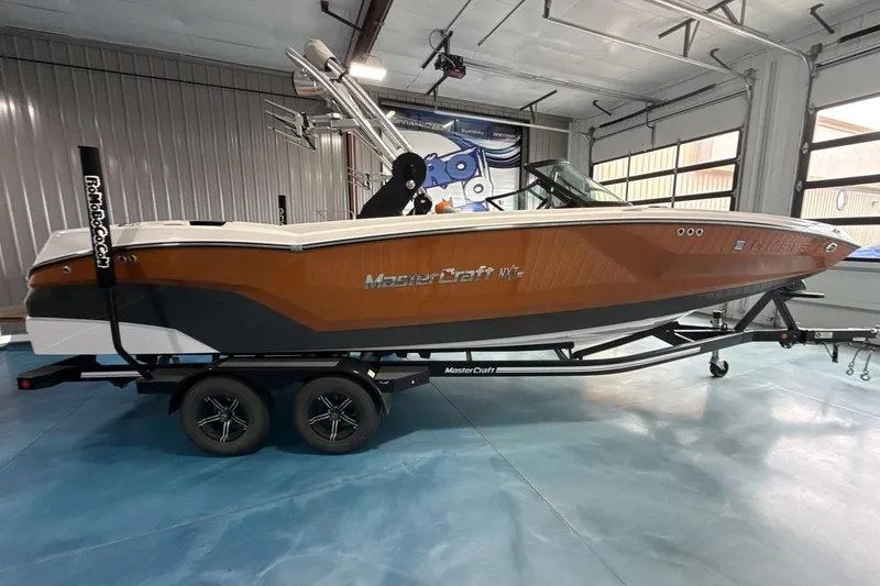Slide: The Image of 2021 MasterCraft NXT24 boat on trailer in indoor storage facility. - 6
