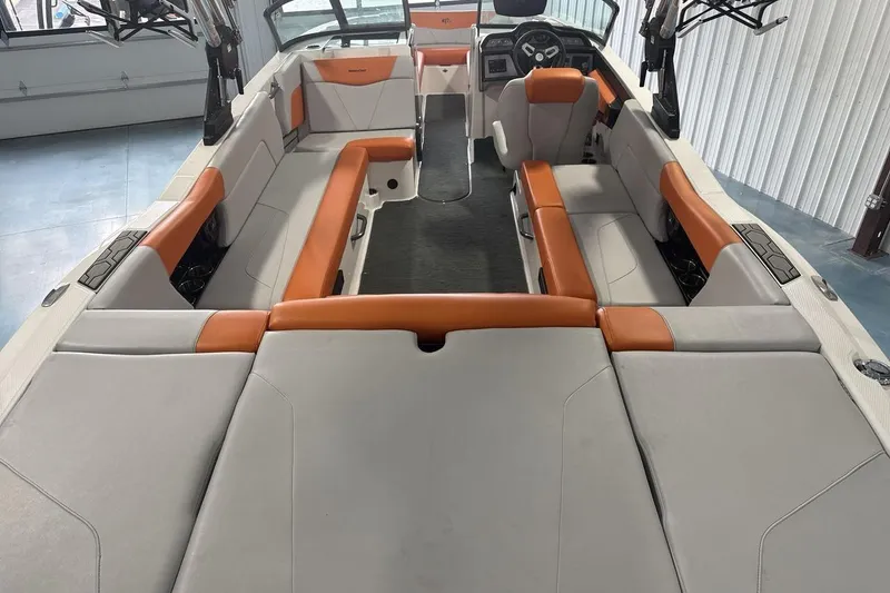 Slide: The Image of 2021 MasterCraft NXT24 boat interior with orange and gray seating, spacious layout. - 9