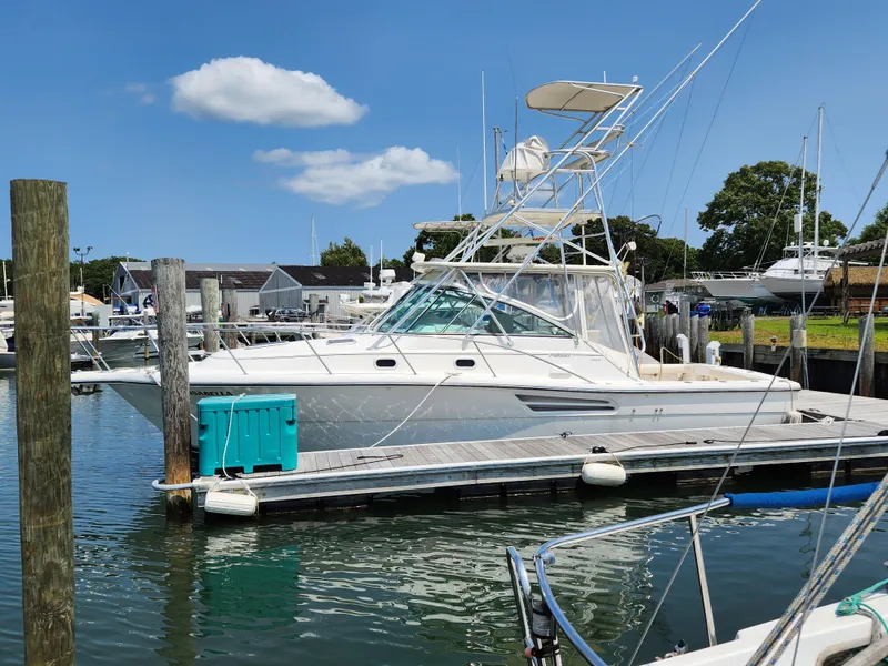 The Image of 2000 Pursuit 3400 Express boat docked at a marina on a sunny day. - 0