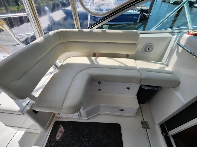 Slide: The Image of 2000 Pursuit 3400 Express boat interior seating area with white cushioned seats. - 10