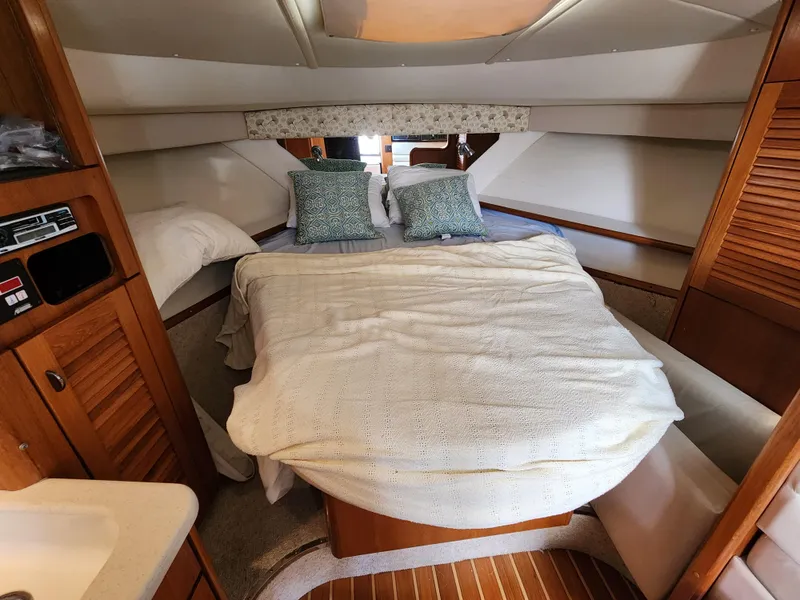 Slide: The Image of 2000 Pursuit 3400 Express cabin with cozy bed and wooden interior. - 11