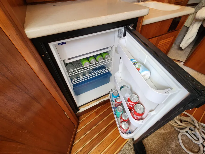 Slide: The Image of Open refrigerator in 2000 Pursuit 3400 Express boat, stocked with beverages. - 13