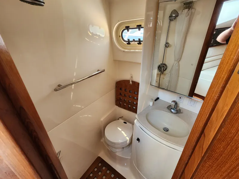 Slide: The Image of 2000 Pursuit 3400 Express boat bathroom with toilet, sink, and shower. - 14