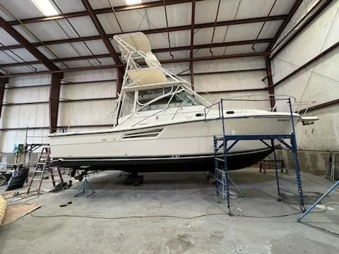 Slide: The Image of 2000 Pursuit 3400 Express boat in a warehouse on stands. - 25