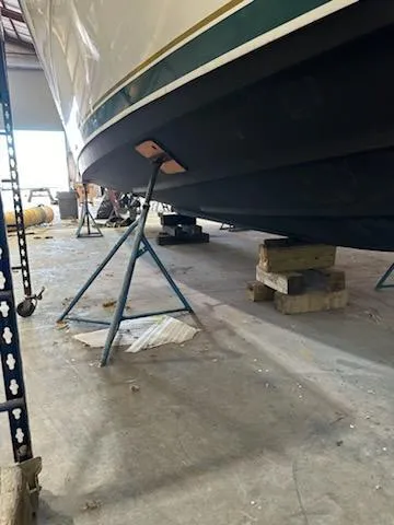 Slide: The Image of 2000 Pursuit 3400 Express boat on stands in a warehouse. - 26