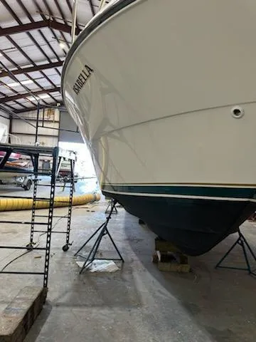 Slide: The Image of 2000 Pursuit 3400 Express boat in storage, supported by stands. - 28