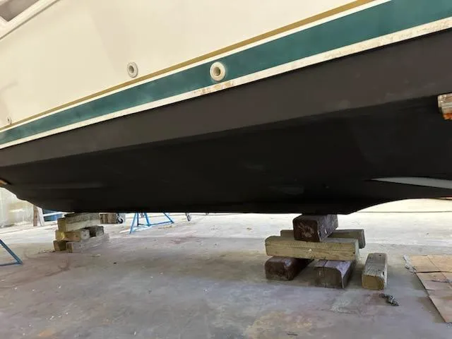 Slide: The Image of 2000 Pursuit 3400 Express boat hull on wooden blocks in a workshop. - 30