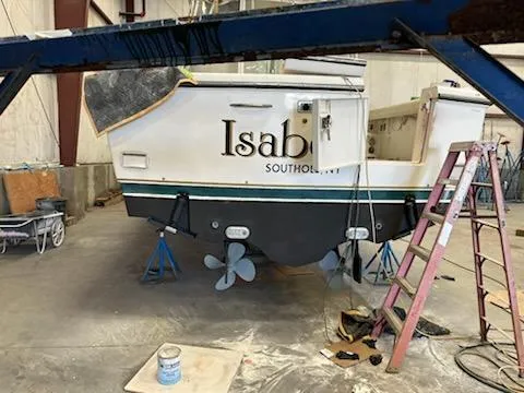 Slide: The Image of 2000 Pursuit 3400 Express boat in a workshop, undergoing maintenance. - 32