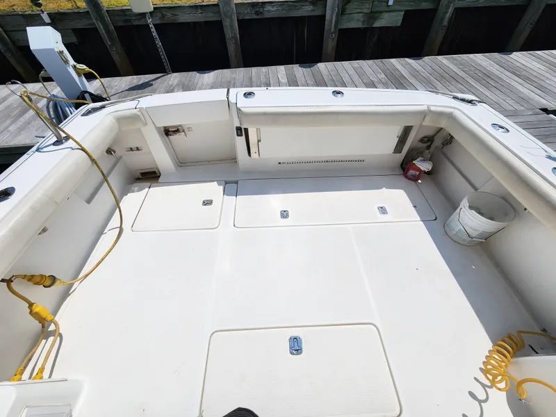 Slide: The Image of 2000 Pursuit 3400 Express boat deck with storage compartments and dock in background. - 4