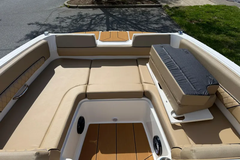 Slide: The Image of 2026 Bayliner D22I boat interior with tan seating and storage compartment. - 10