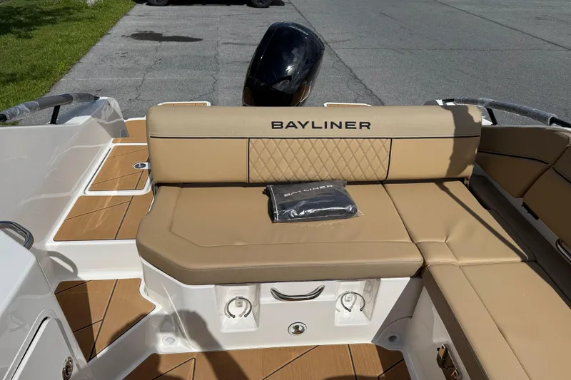Slide: The Image of 2026 Bayliner D22I boat interior with tan seating and branded cushion on deck. - 6