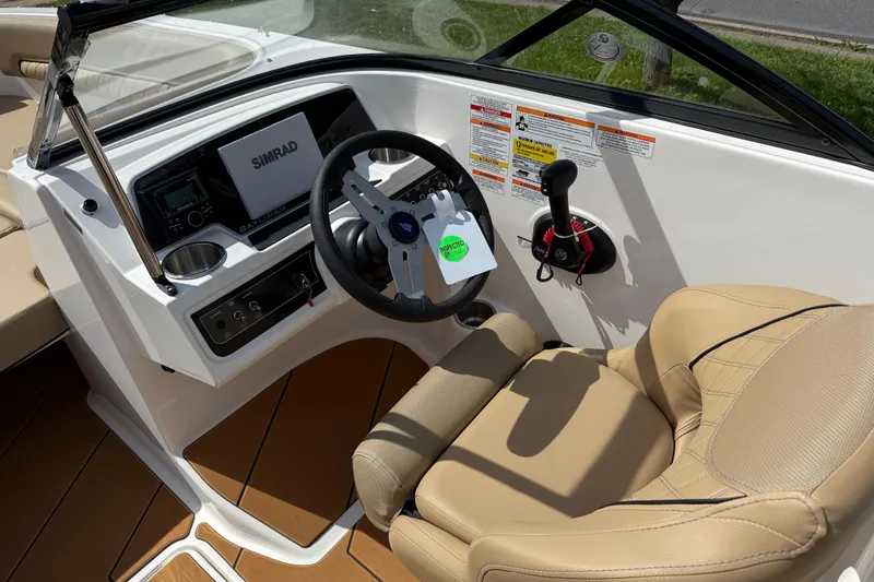 Slide: The Image of 2026 Bayliner D22I boat cockpit with Simrad display and beige seating. - 7