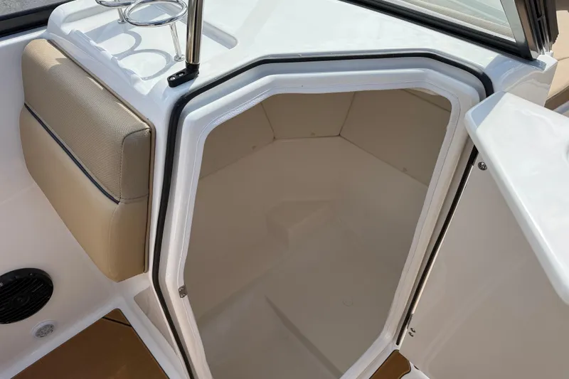 Slide: The Image of 2026 Bayliner D22I boat interior cabin with open door and beige seating. - 9