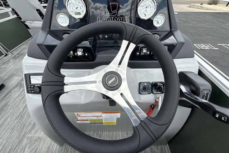 Slide: The Image of Steering wheel and dashboard of 2026 Landau Alure boat, featuring modern controls and gauges. - 14
