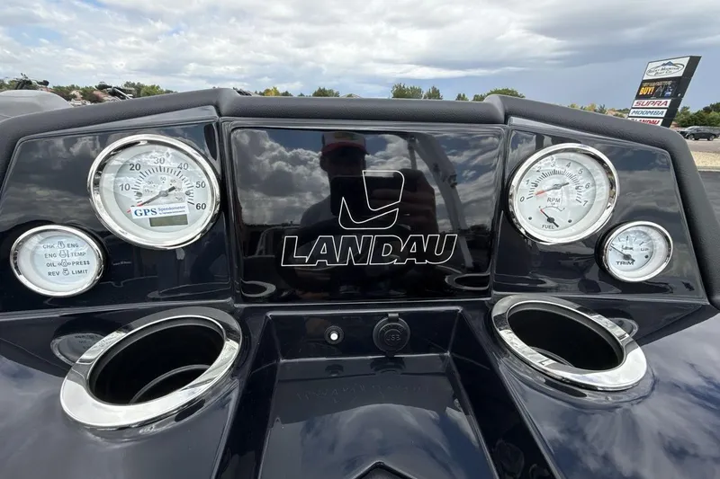 Slide: The Image of Dashboard of 2026 Landau Alure boat with gauges and logo under cloudy sky. - 15