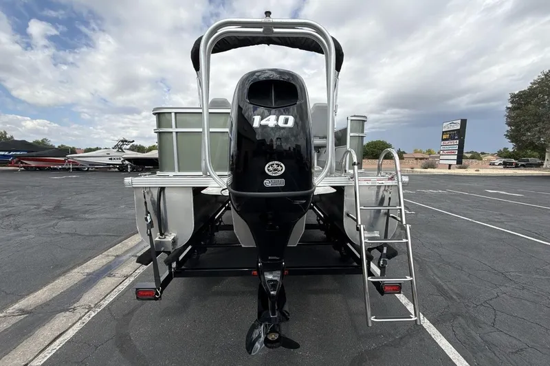 Slide: The Image of 2026 Landau Alure boat with 140 HP engine, parked outdoors under cloudy sky. - 4