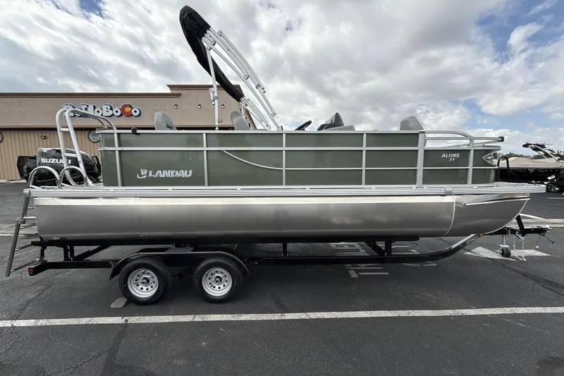 Slide: The Image of 2026 Landau Alure pontoon boat on trailer, parked outdoors under cloudy sky. - 6
