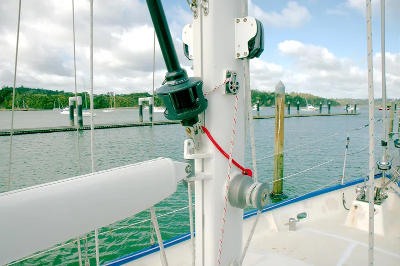 Slide: The Image of Crealock 1997 custom schooner deck with rigging, docked in a scenic marina. - 14