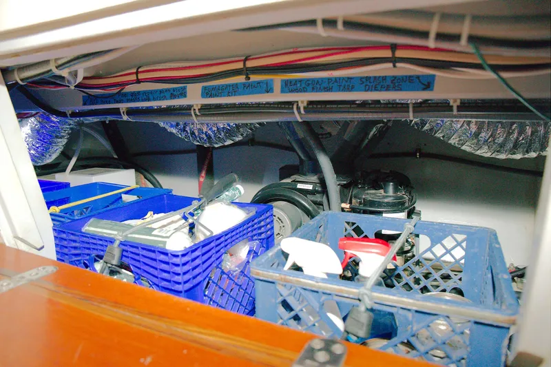 Slide: The Image of Storage area inside 1997 Crealock custom schooner with organized blue crates and equipment. - 18