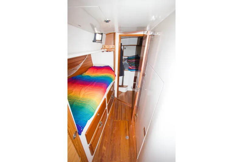 Slide: The Image of Interior of 1997 Crealock custom schooner with colorful bedding and wooden cabinetry. - 24