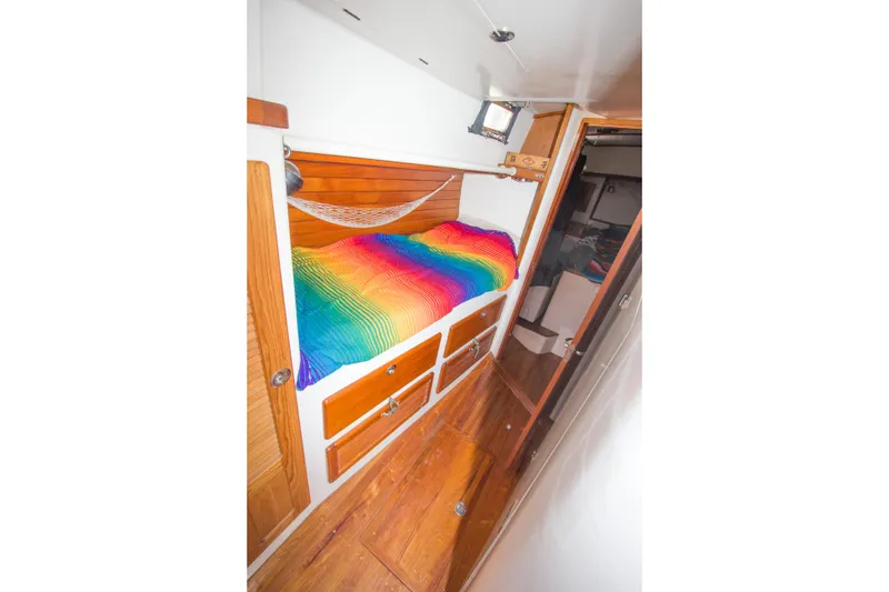 Slide: The Image of Cozy cabin interior of 1997 Crealock schooner with vibrant rainbow bedding and wooden accents. - 25