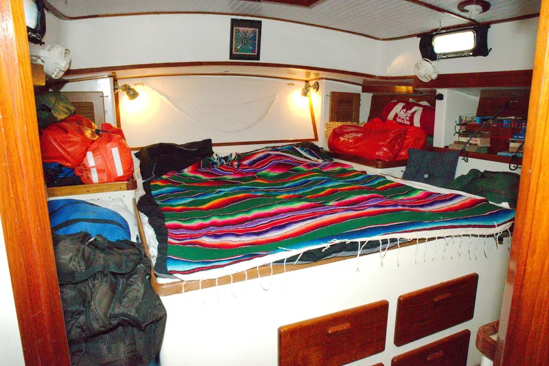 Slide: The Image of Cozy cabin interior of 1997 Crealock custom schooner with colorful blanket and storage. - 7