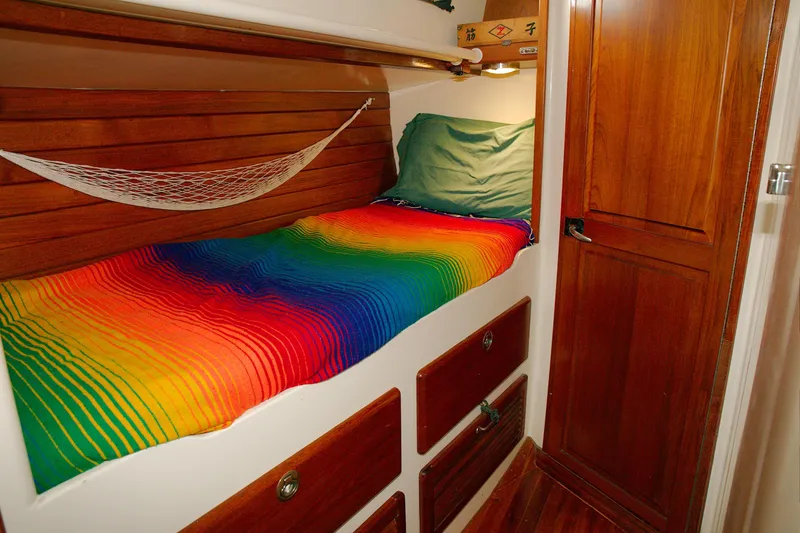 Slide: The Image of Cozy cabin interior of 1997 Crealock schooner with vibrant rainbow bedding and wooden accents. - 9