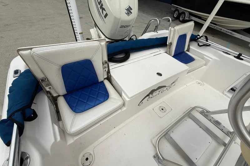 Slide: The Image of 2019 Blue Wave 2200 PureBay boat interior with blue and white seating and Suzuki engine. - 12