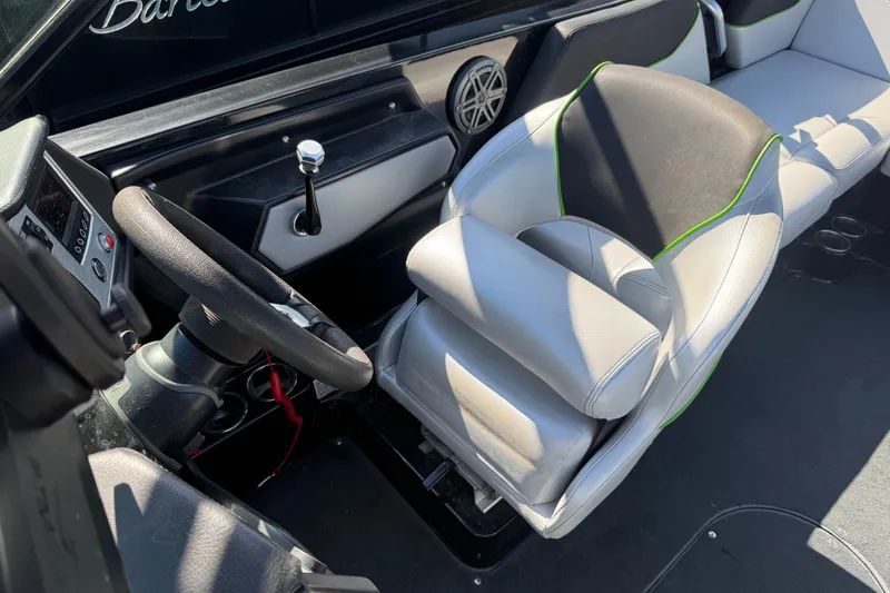 Slide: The Image of Interior of a 2016 MasterCraft NXT22 boat featuring steering wheel and seating. - 13