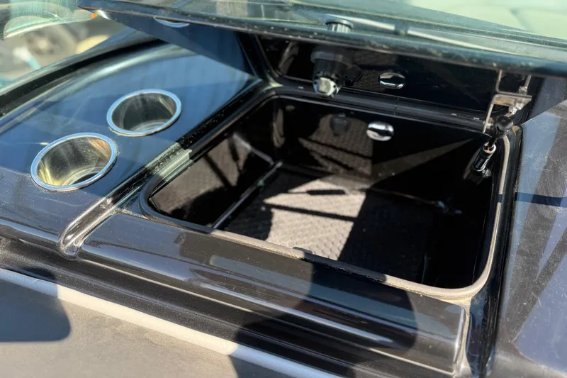 Slide: The Image of Open storage compartment in 2016 MasterCraft NXT22 boat with cup holders. - 20