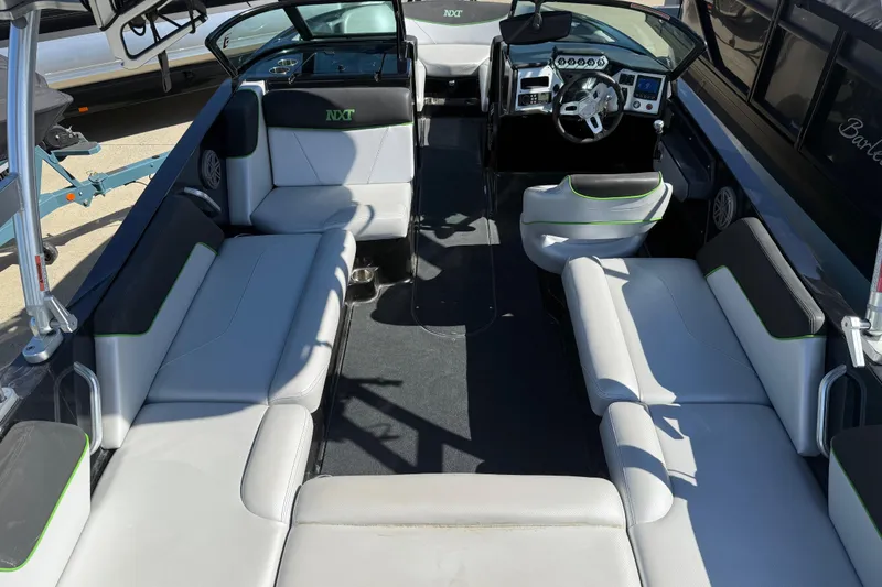 Slide: The Image of 2016 MasterCraft NXT22 boat interior with spacious seating and modern dashboard design. - 25