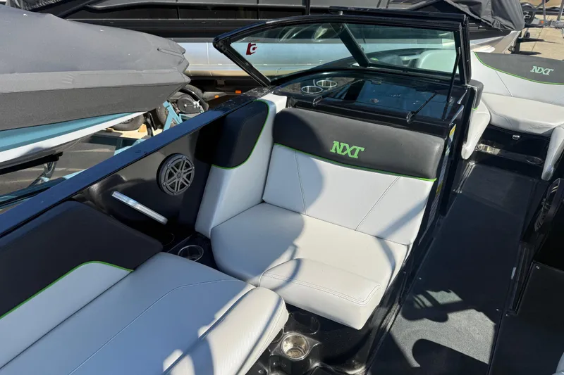 Slide: The Image of 2016 MasterCraft NXT22 boat interior with black and white seating, green accents. - 6