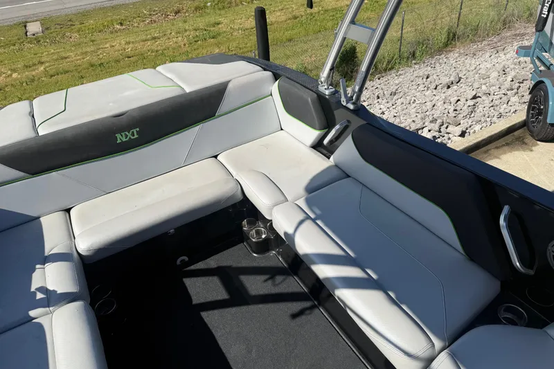 Slide: The Image of 2016 MasterCraft NXT22 boat interior with gray seating and green accents. - 8