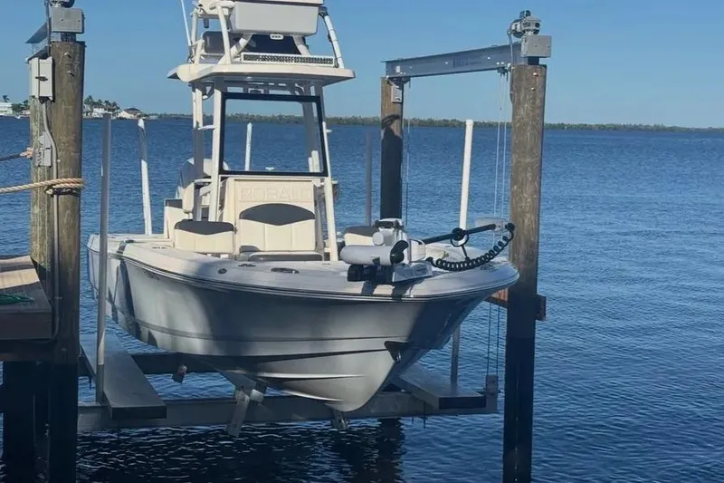 Slide: The Image of 2020 Robalo 246 Cayman SD boat on lift by serene waterfront. - 2