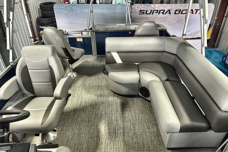 Slide: The Image of 2026 Landau Island Breeze 23F pontoon boat interior with gray seating and steering console. - 12