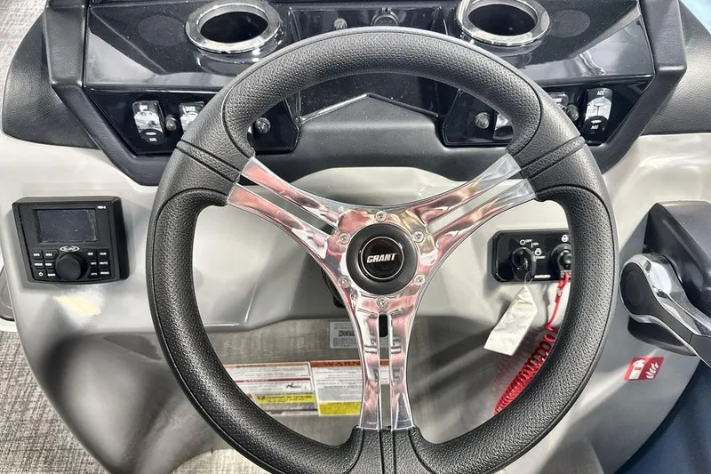 Slide: The Image of Steering wheel of 2026 Landau Island Breeze 23F boat with control panel and cup holders. - 14