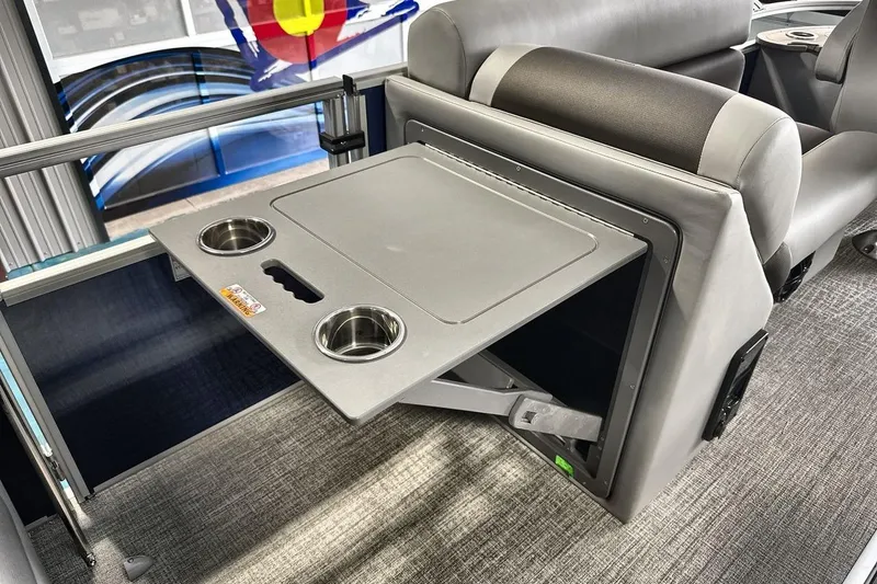 Slide: The Image of 2026 Landau Island Breeze 23F boat interior with foldable table and cup holders. - 17