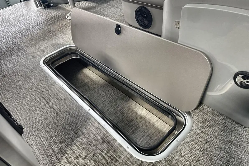 Slide: The Image of 2026 Landau Island Breeze 23F boat interior storage compartment with open hatch on carpeted floor. - 18