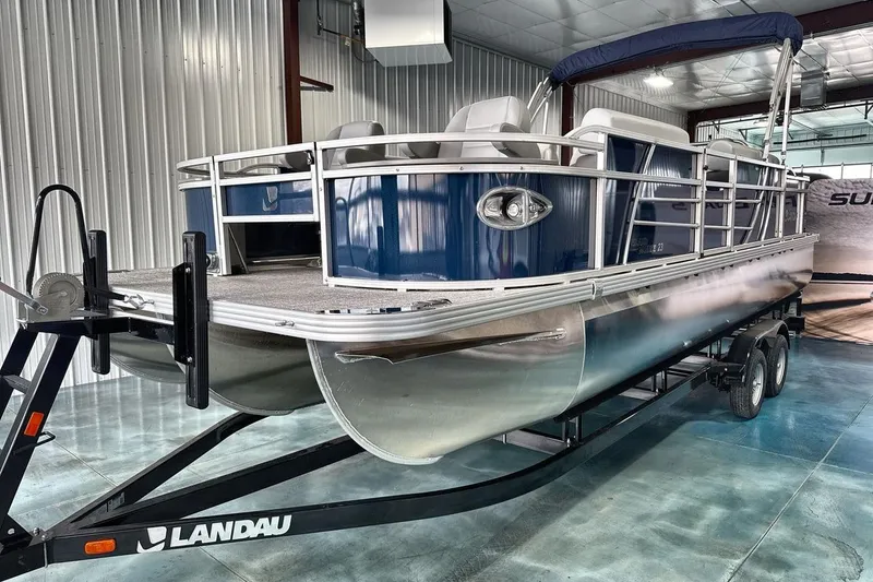 Slide: The Image of 2026 Landau Island Breeze 23F pontoon boat on trailer in a metal garage. - 3
