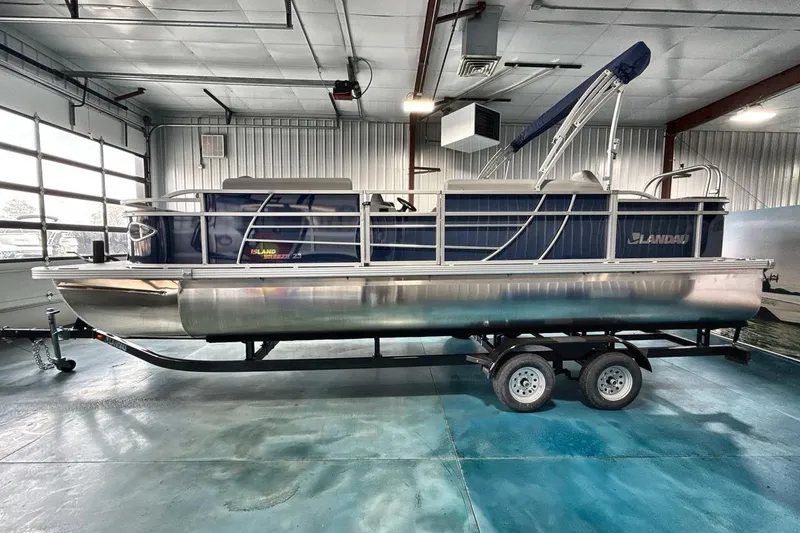 Slide: The Image of 2026 Landau Island Breeze 23F pontoon boat in a showroom on a trailer. - 4