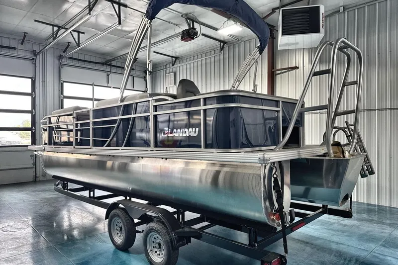 Slide: The Image of 2026 Landau Island Breeze 23F pontoon boat in a garage setting. - 5