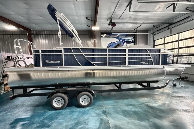Slide: The Image of 2026 Landau Island Breeze 23F pontoon boat in a showroom on a trailer. - 8