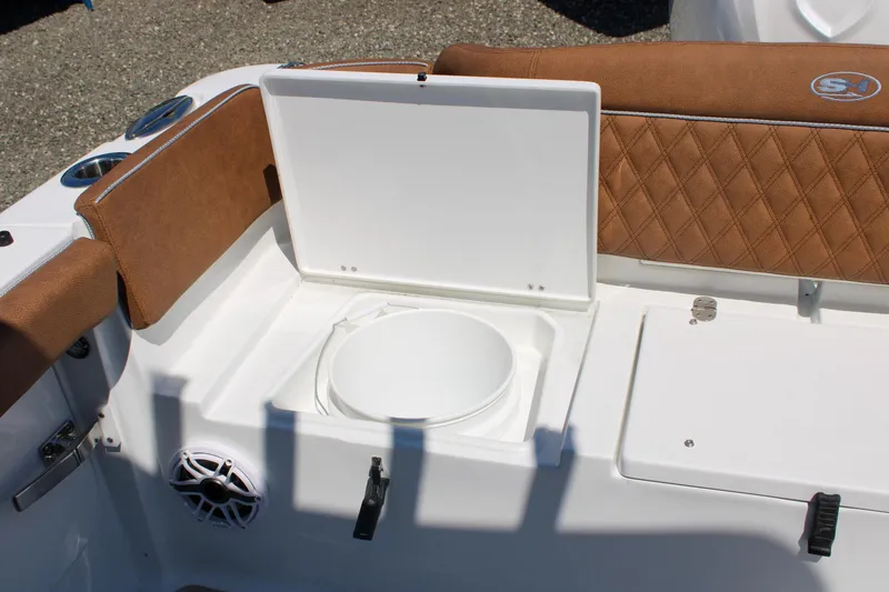 Slide: The Image of 2026 Sea Hunt Ultra 255 SE boat interior with brown seating and storage compartment. - 10