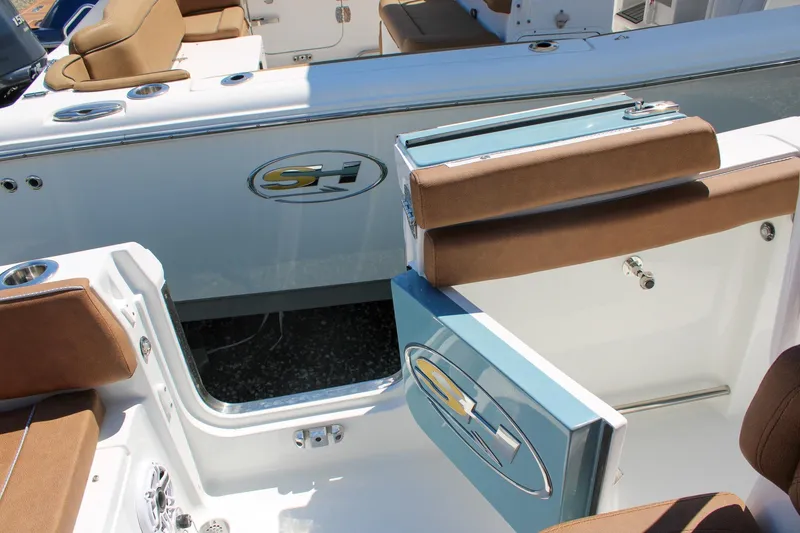 Slide: The Image of 2026 Sea Hunt Ultra 255 SE boat interior with open side door and cushioned seating. - 12