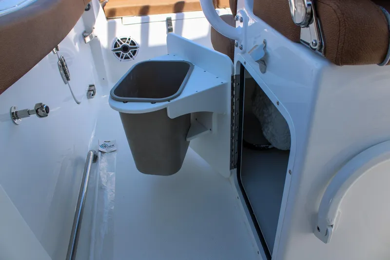 Slide: The Image of Interior of 2026 Sea Hunt Ultra 255 SE boat with storage compartment and trash bin. - 16