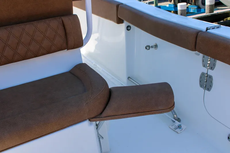 Slide: The Image of 2026 Sea Hunt Ultra 255 SE boat interior with brown cushioned seating and white accents. - 19