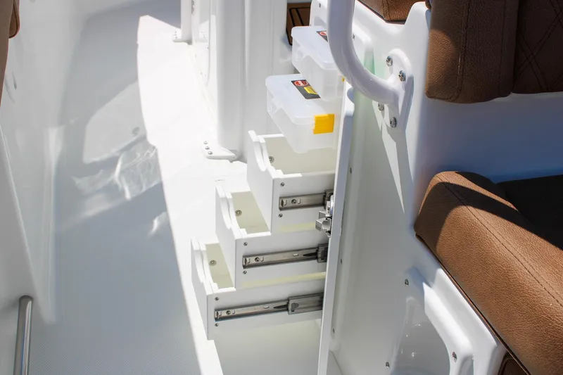 Slide: The Image of 2026 Sea Hunt Ultra 255 SE boat interior with storage drawers and brown seating. - 20